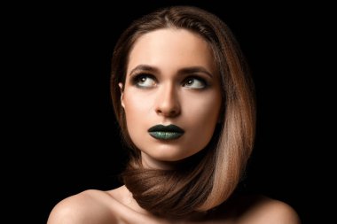 Güzel genç kadın koyu arka plan üzerinde parlak makyaj ile