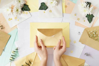 Kadın masasında görmek birçok Zarflar ve çiçek dekorasyonu