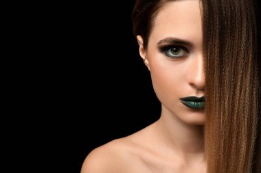 Güzel genç kadın koyu arka plan üzerinde parlak makyaj ile