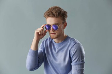 Gri arka planda şık bir genç adam.