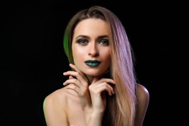 Güzel genç kadın koyu arka plan üzerinde parlak makyaj ile