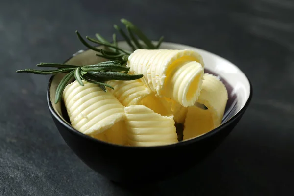 Bowl with butter curls on table