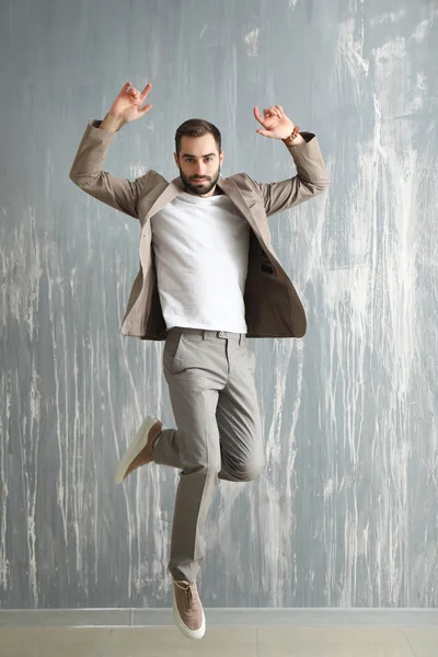 Handsome Fashionable Man Jumping Grunge Wall — Stock Photo, Image