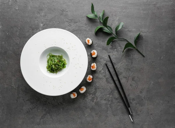 Plaat Met Lekkere Sushi Rolt Algen Eetstokjes Grijze Tafel — Stockfoto