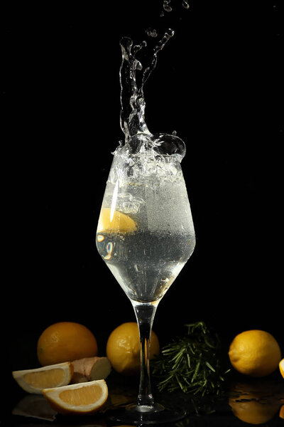 Glass of fresh lemonade with splash on dark background