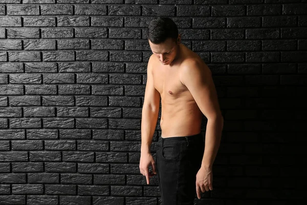 Sportlicher Junger Mann Gegen Dunkle Backsteinmauer — Stockfoto