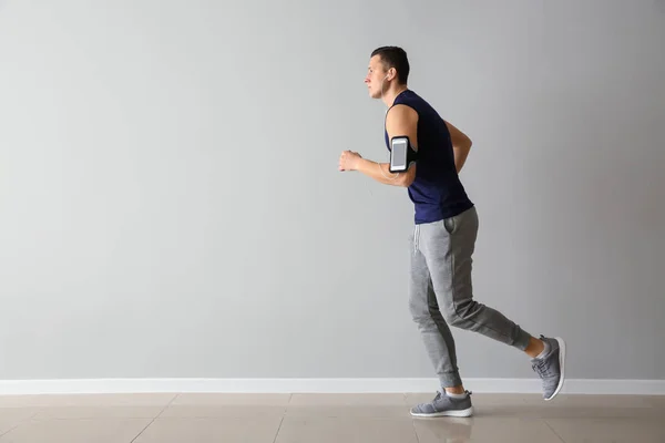 Sporty Young Man Running Light Wall — Stock Photo, Image