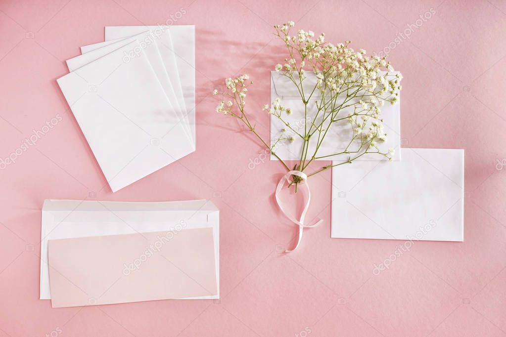 Paper envelopes and flowers on color background