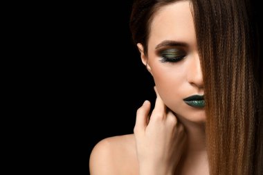 Güzel genç kadın koyu arka plan üzerinde parlak makyaj ile