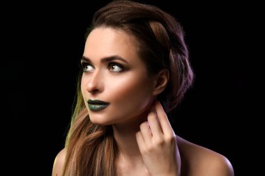 Güzel genç kadın koyu arka plan üzerinde parlak makyaj ile