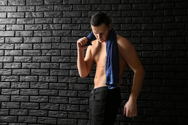 暗いレンガの壁にタオルでスポーティな若い男 — ストック写真