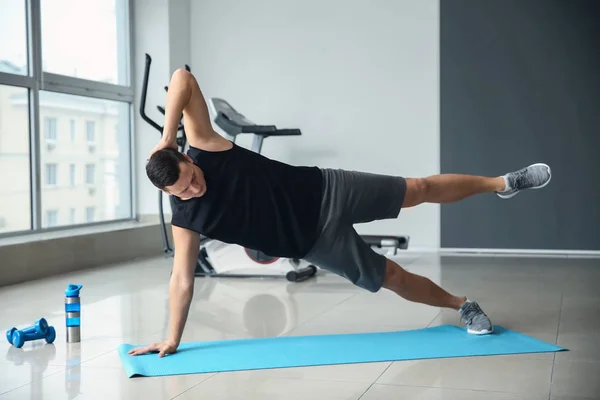 Sporty young man training in gym