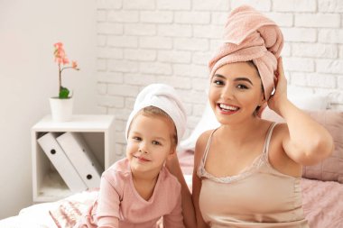 Sevimli küçük kızını yatağa oturmuş duş sonra annesiyle