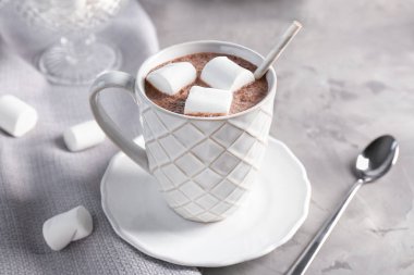 Sıcak kakao marshmallows gri masada içkiyle fincan