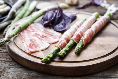 Ahşap masa, closeup kuşkonmaz pastırma sarılmış