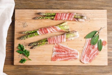 Kurulu pastırma ile kuşkonmaz ahşap masanın üzerine sarılmış.