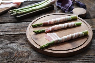 Kurulu pastırma ile kuşkonmaz ahşap masanın üzerine sarılmış.