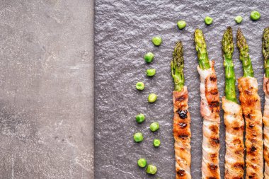 Kurulu pastırma ile kuşkonmaz gri masanın üzerine sarılmış.