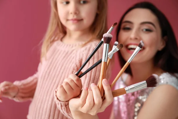 Menina Bonito Sua Mãe Com Pincéis Maquiagem Fundo Cor Close — Fotografia de Stock