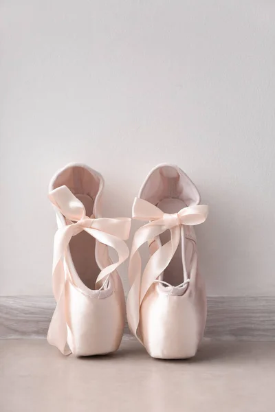 Ballet shoes on floor near wall