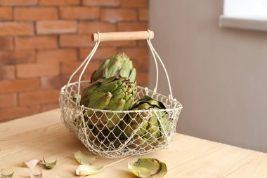 Ahşap masa üzerinde lezzetli çiğ Enginarlı sepeti