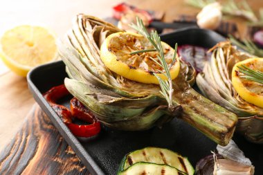 Lezzetli ızgara enginar ve ahşap masa, closeup sebze ile pan