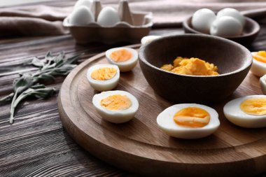Tahta kesme haşlanmış yumurta ve ahşap masa üzerinde püresi yumurta sarısı ile