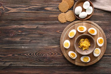 Kurulu ile haşlanmış yumurta, yumurta sarısı ve waffle ahşap masanın üstüne kesmek