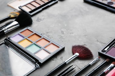 Gri arka plan üzerinde kozmetik ile profesyonel makyaj fırçaları