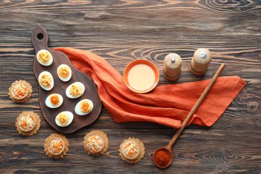 Tartlets tarihinde ahşap masa ile lezzetli baharatlı ve acılı yumurta