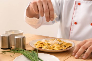 Erkek Şef lezzetli mantı masaya hizmet için hazırlanıyor