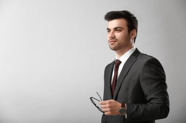 Işık arka plan üzerinde yakışıklı genç işadamı portresi