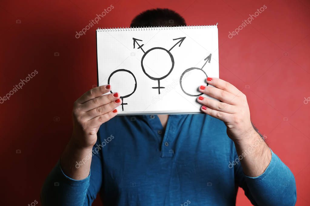 Man with manicure showing male, female and transgender's symbols on color background