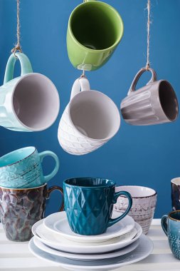 Farklı çay bardak ve tabaklar renk arka plan üzerinde ile raf