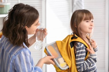 Sevimli kızı evde sırt çantasına beslenme çantası ambalaj anne