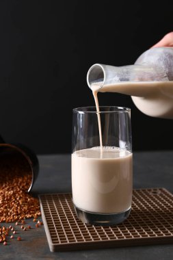 Leziz buğday süt şişe cam içine karanlık masaya dökülen