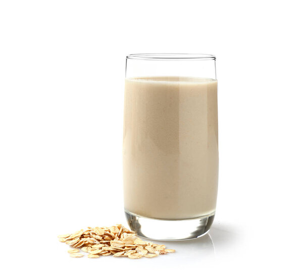 Glass of tasty oat milk on white background