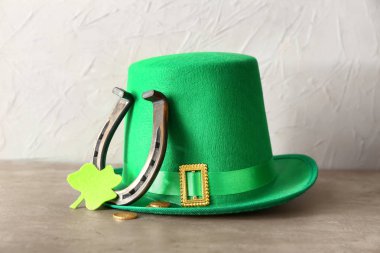 Gri masada St Patrick's Day için cin'ın şapkası, at nalı, sikke ve yonca ile kompozisyon