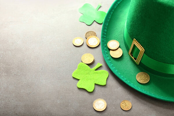 Composition with leprechaun's hat, coins and clover for St. Patrick's Day on grey background