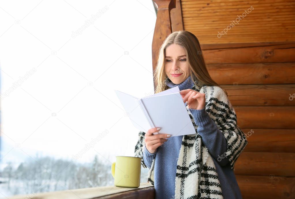 Beautiful woman reading book on winter day