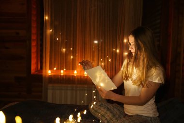 Güzel kadın karanlıkta parlayan ışıklar ile masal okuma