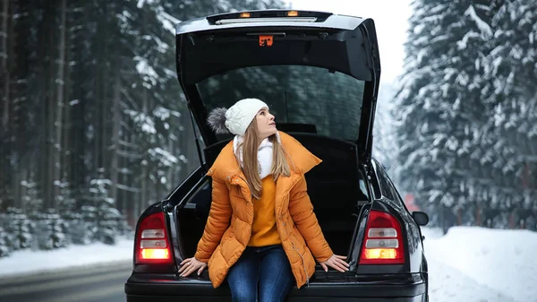 冬のリゾート地での車の近くの若い女性 — ストック写真