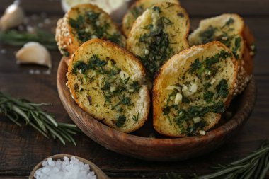 Lezzetli bir kase sarımsaklı ekmek ahşap masanın üstüne kesmek