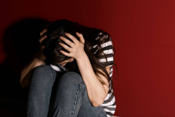 Young depressed woman thinking about suicide on color background