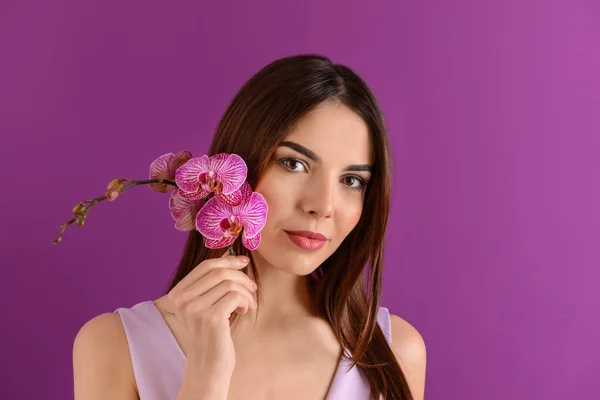 Vacker Ung Kvinna Med Orkidé Blommor Färgbakgrund — Stockfoto