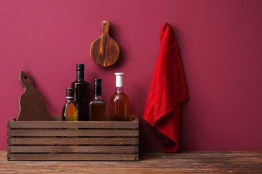 Petrol renk duvarının yakınında masada şişe ile ahşap kutu