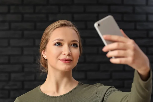 Young Woman Taking Selfie Mobile Phone Dark Brick Background — Stock Photo, Image