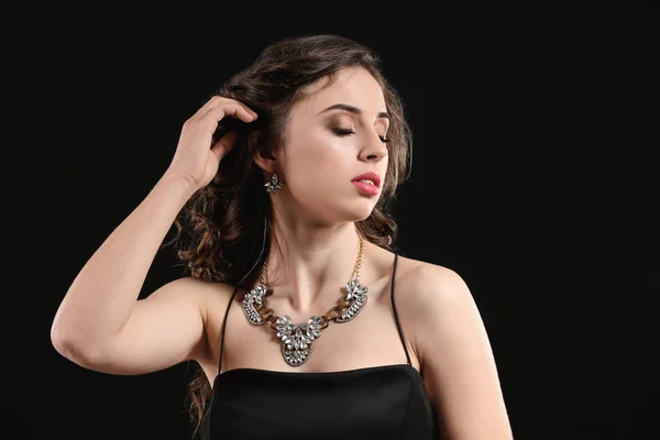 暗い背景に美しい宝石を持つ若い女性 — ストック写真