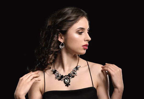 暗い背景に美しい宝石を持つ若い女性 — ストック写真