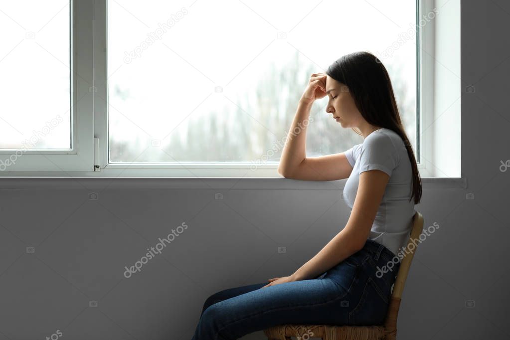 Young depressed woman thinking about suicide at home